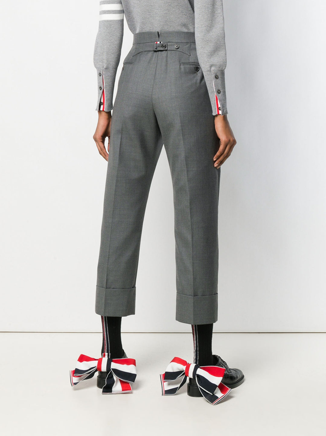 Thom Browne Classic Backstrap Trouser in medium grey wool with high waist, pressed creases, and wide turn-up cuffs, flat lay on white background