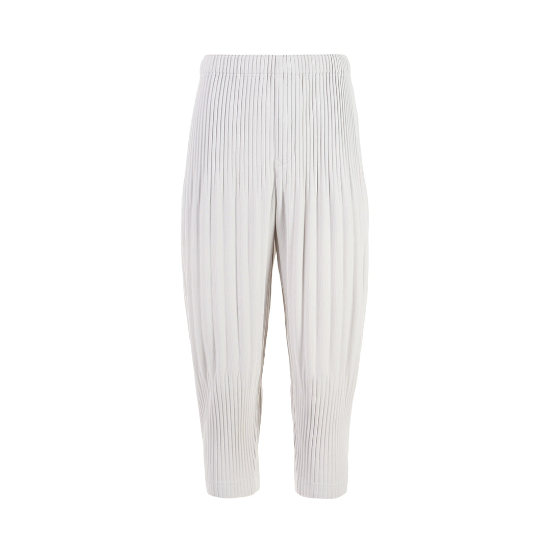 Homme Plissé Issey Miyake Long Wide Pleated Pants in black with all-over vertical pleating and tapered leg, front view on white background.