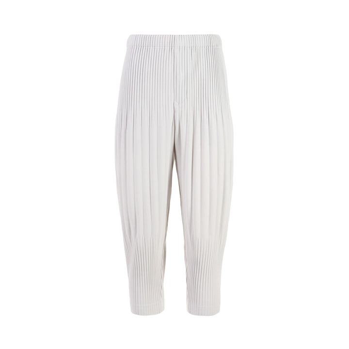 Homme Plissé Issey Miyake Long Wide Pleated Pants in black with all-over vertical pleating and tapered leg, front view on white background.