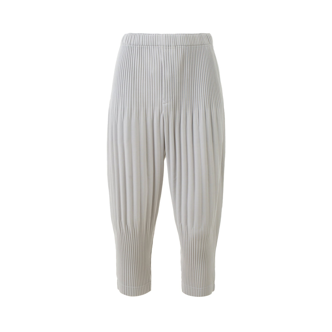 Homme Plissé Issey Miyake Long Wide Pleated Pants in black with all-over vertical pleating and tapered leg, front view on white background.