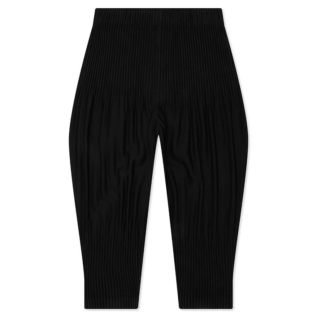 Homme Plissé Issey Miyake Long Wider Pants in black with signature pleated fabric and relaxed wide-leg silhouette, flat lay view