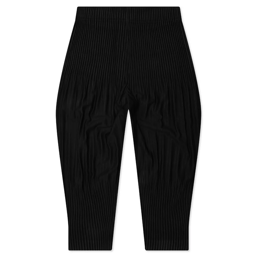 Homme Plissé Issey Miyake Long Wider Pants in black with signature pleated fabric and relaxed wide-leg silhouette, flat lay view