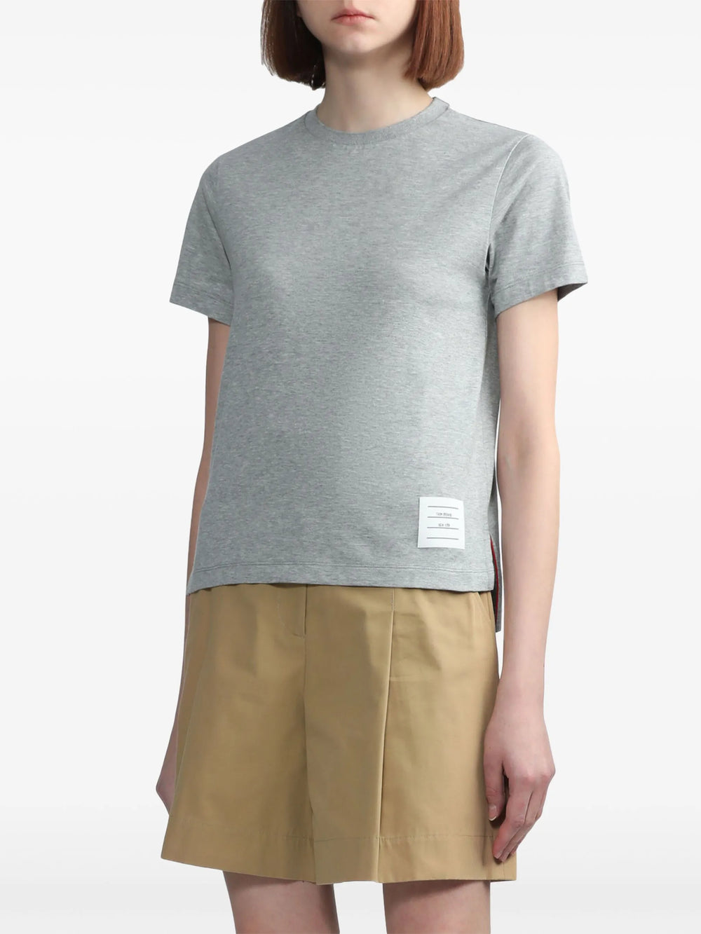 Thom Browne Jersey Relaxed Side Slit Tee in heather grey, featuring a crew neckline, short sleeves, side hem slits, and signature woven label tab