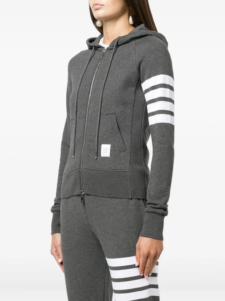Thom Browne grey marl zip-up hoodie with four-bar white and grey stripe detail on the upper sleeve, full silver zip, drawstring hood, and front kangaroo pockets
