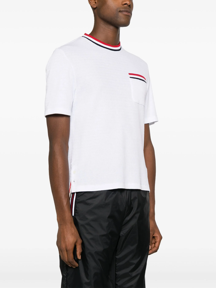 Thom Browne white short sleeve racking stitch crewneck tee with red, white, and navy stripe collar and chest pocket trim