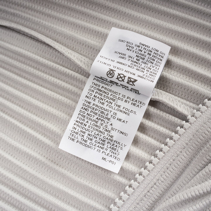 Homme Plissé Issey Miyake Basics Zip-Up Cardigan in light grey with all-over steam pleating, funnel neck, and full-length tonal zip, displayed flat on white background - view 4