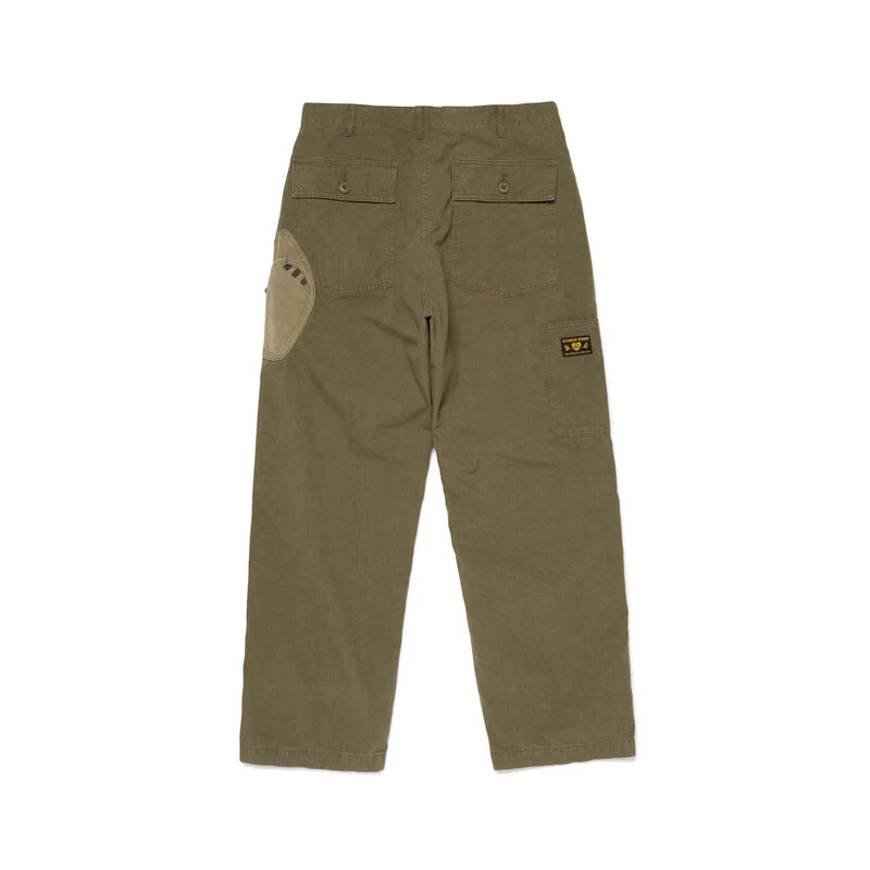 Human Made Baker Pants in washed olive green, shown flat with a relaxed wide-leg silhouette, contrast thigh patch, and front patch pockets