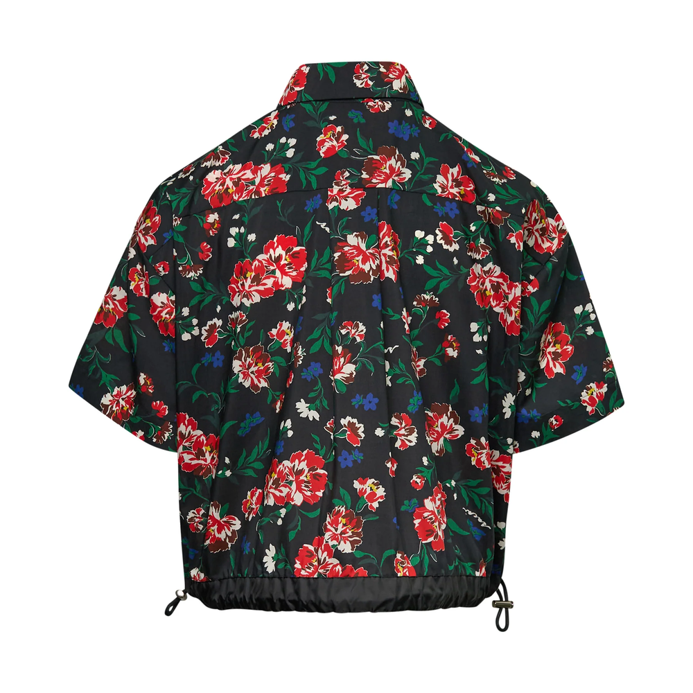 sacai Floral Short Sleeve Shirt in black with an all-over red peony print, featuring a cape overlay, flap chest pockets, and a drawstring hem with black nylon hem band