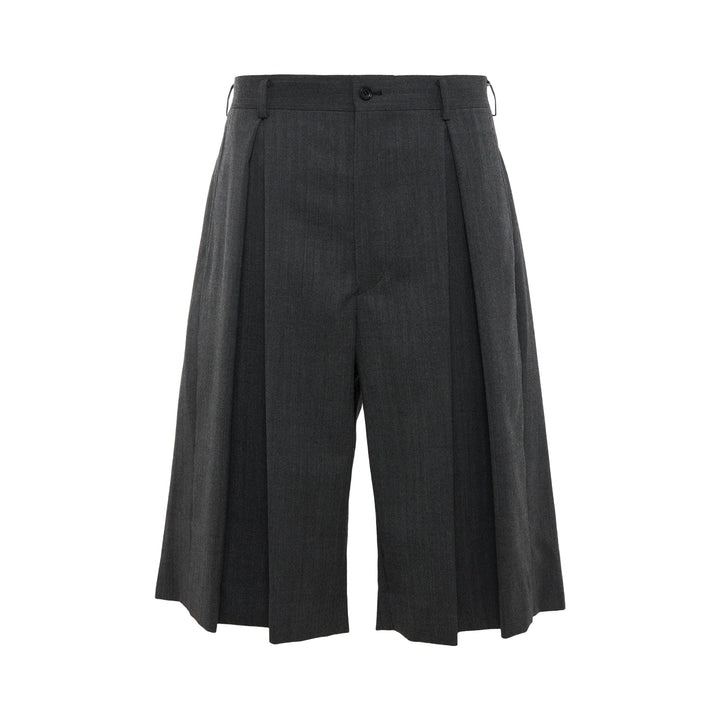 COMME des GARCONS HOMME PLUS Pleated Wide-Leg Shorts in charcoal grey with deep forward pleats and high-rise waistband, front view on white background