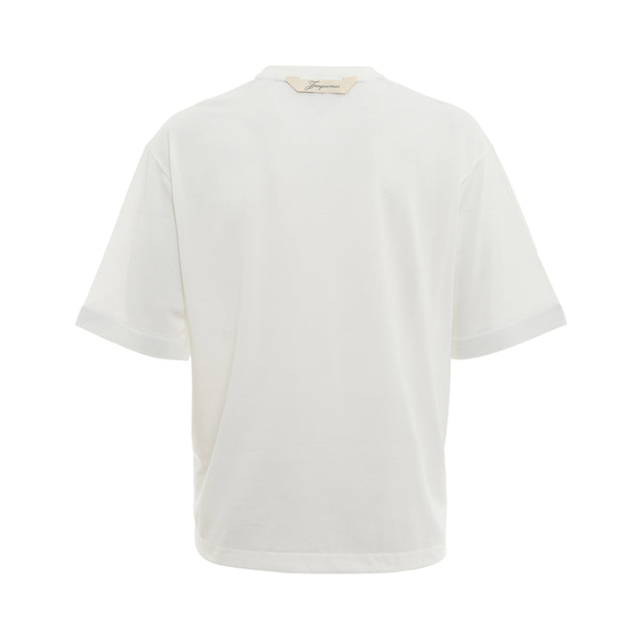 JACQUEMUS Round Square T-Shirt in white with a relaxed boxy fit and crew neckline, displayed on a flat ghost mannequin against a white background.
