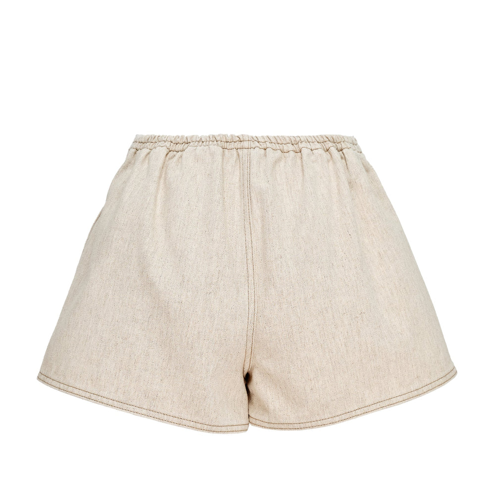 Jacquemus De-Nîmes Amelo high-rise tailored shorts in natural ecru denim with contrast topstitching, front pleats, and embroidered monogram logo at hem