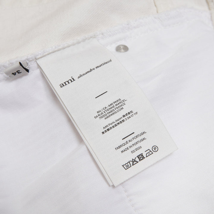 AMI Paris Heritage Denim Shorts in off-white with high-rise waist, five-pocket design, and signature heritage label patch