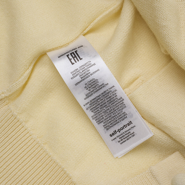 Self-Portrait butter yellow knit cardigan with lavender floral embroidery on the chest, pearl buttons, point collar, and ribbed hem and cuffs