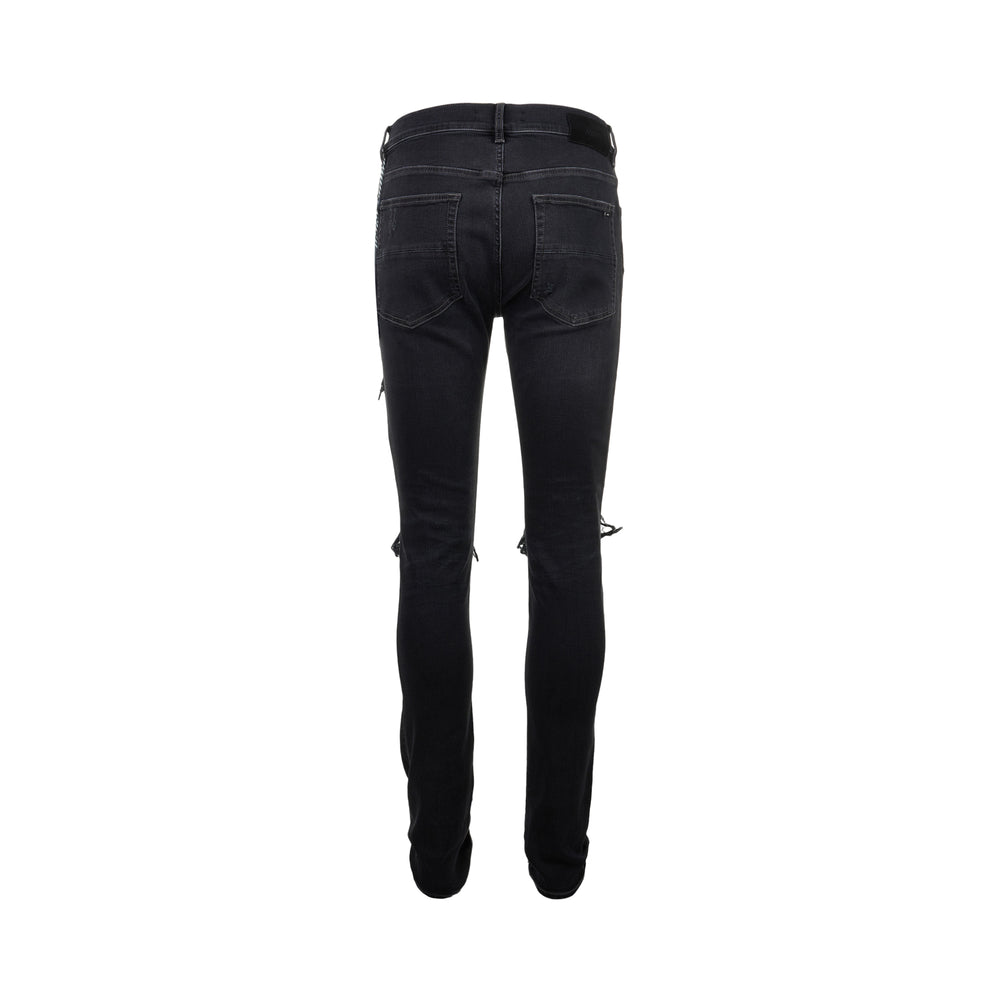 Amiri Camo MX1 Jeans in washed black denim with distressed knee rips and camouflage underlay patches, skinny fit, front view