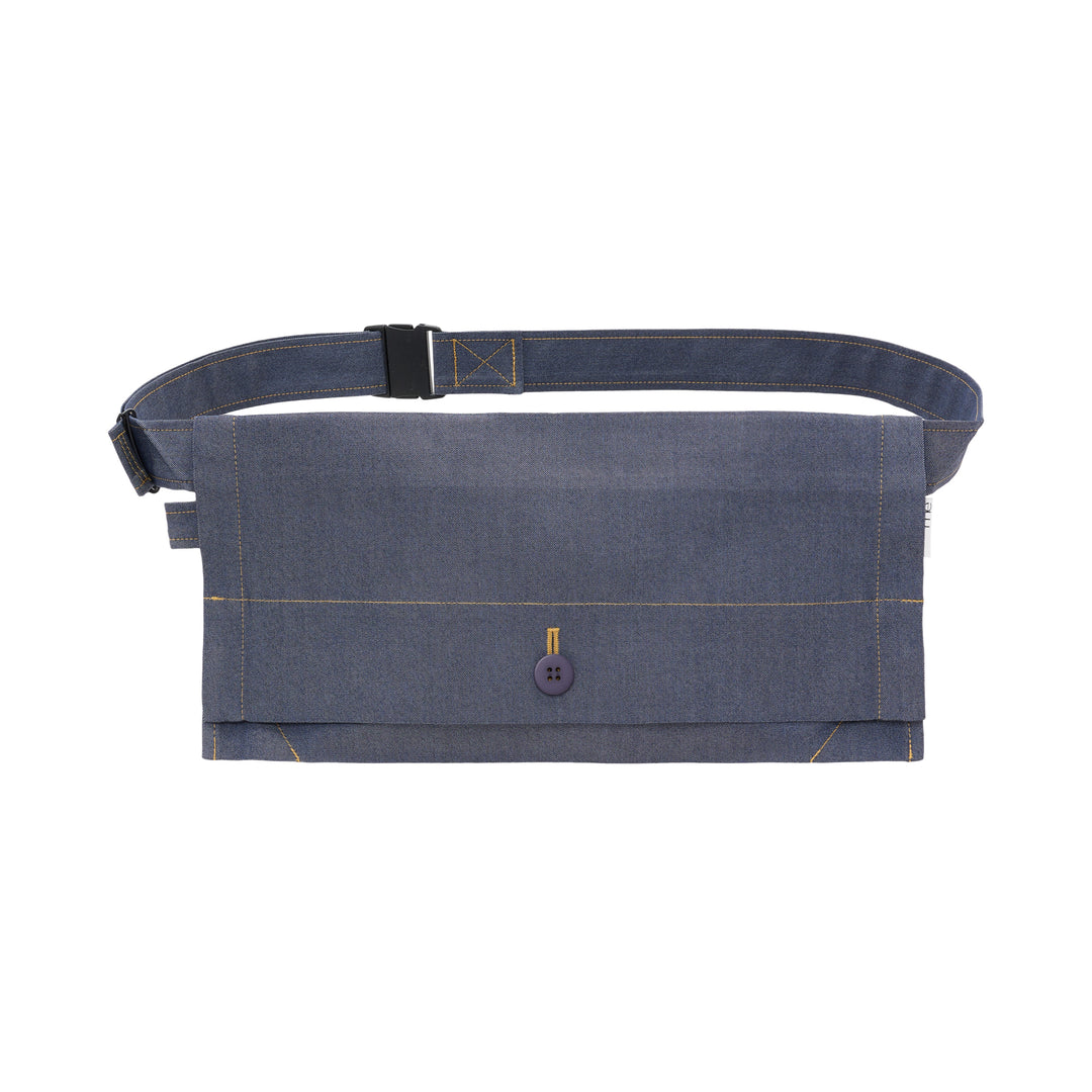 me Issey Miyake Flat Denim Belt Bag in chambray blue with contrast golden stitching, a navy button closure, and an adjustable buckle strap, shown against a white background