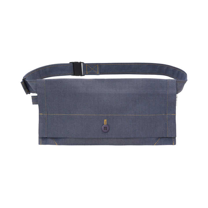 me Issey Miyake Flat Denim Belt Bag in chambray blue with contrast golden stitching, a navy button closure, and an adjustable buckle strap, shown against a white background