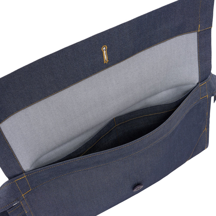 me Issey Miyake Flat Denim Belt Bag in chambray blue with contrast golden stitching, a navy button closure, and an adjustable buckle strap, shown against a white background - view 4