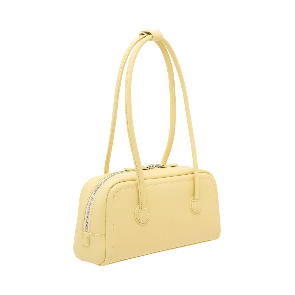 Marge Sherwood Soft Boston EW bag in butter yellow smooth leather, featuring a single looped top handle, double zip closure with silver hardware, and embossed logo on the front panel - view 2