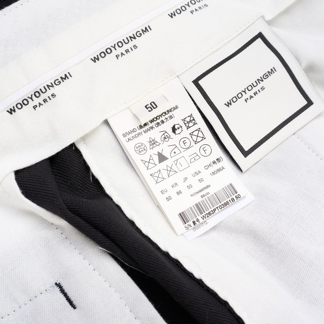 Wooyoungmi black pleated high-rise trousers with double front pleats and side metal buckle adjuster, displayed flat on white background - view 3