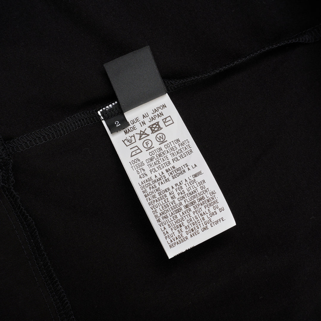 Y's black oversized round neck shirt dress with short folded cuffs, layered T-shirt upper, and buttoned skirt panel, displayed on white background - view 3