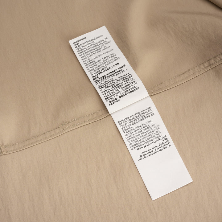 AMI Alexandre Mattiussi Shark Collar Boxy Short Sleeve Shirt in tan and black with contrast cream piping and button-through front, flat lay on white background - view 4