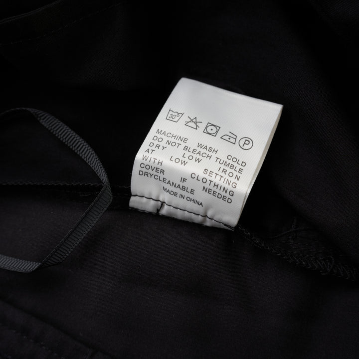 Black longline tailored shorts with a front box pleat, belt loops and concealed fly closure, shown from the front - view 4