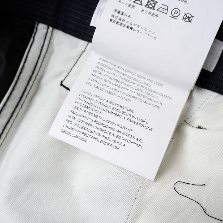 Navy pinstripe pleated cargo shorts by Comme des Garçons Shirt with a wide-leg cut, flap pockets and button fly, shown from the front - view 4