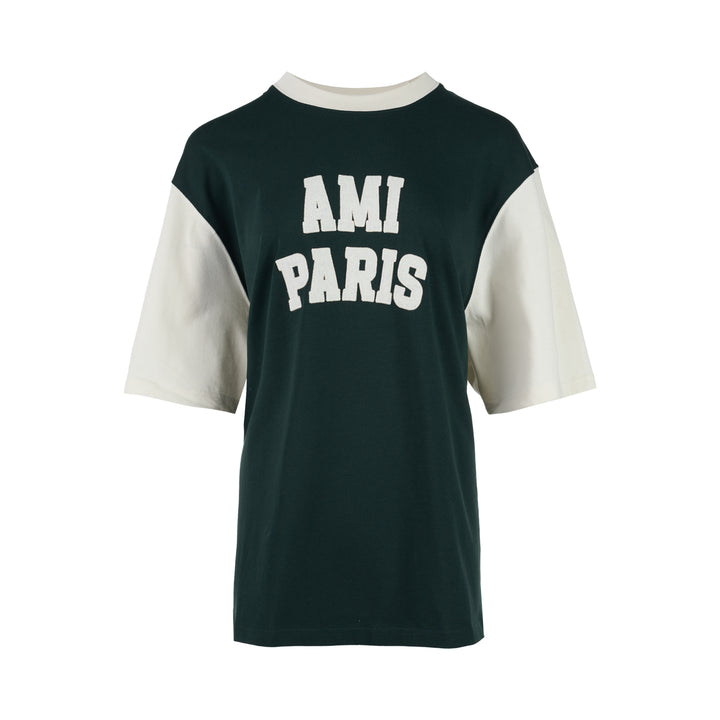 AMI Paris oversized t-shirt in dark green with cream contrast sleeves and collar, featuring white felt AMI PARIS lettering across the chest