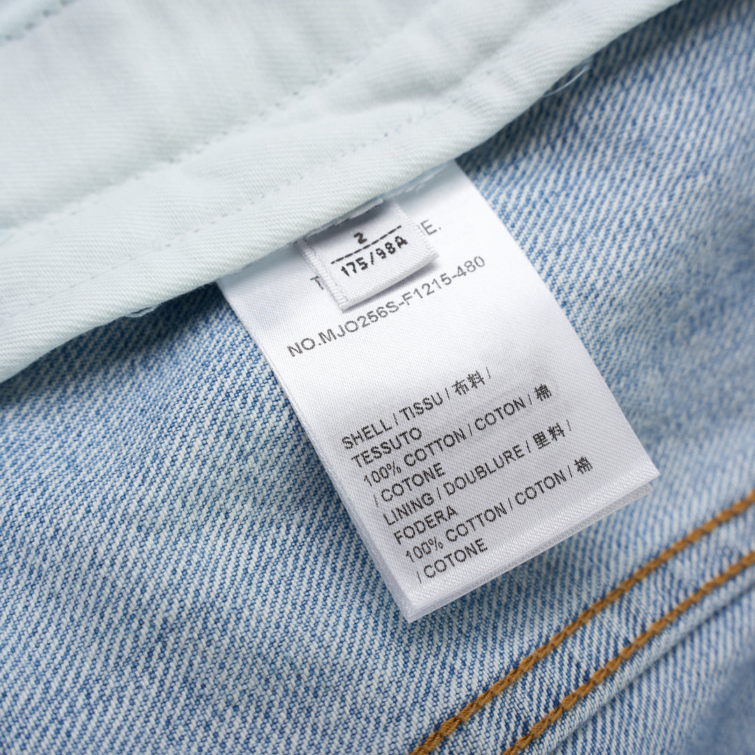 Thom Browne Backstrap Utility Jacket in light-wash denim with twin chest flap pockets and brass buttons, shown from the front - view 3
