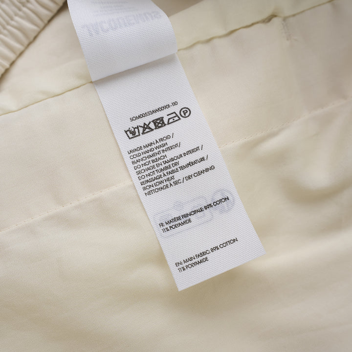 Jacquemus Le Short Pyjama cream pleated shorts with elasticated waistband, button closure and side piping, shown from the front - view 3