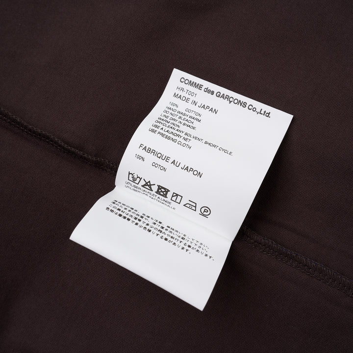 Comme des Garçons Homme Logo Tag Boxy Tee in dark brown with ribbed crewneck, dropped shoulders and wide short sleeves, shown flat from the front - view 3