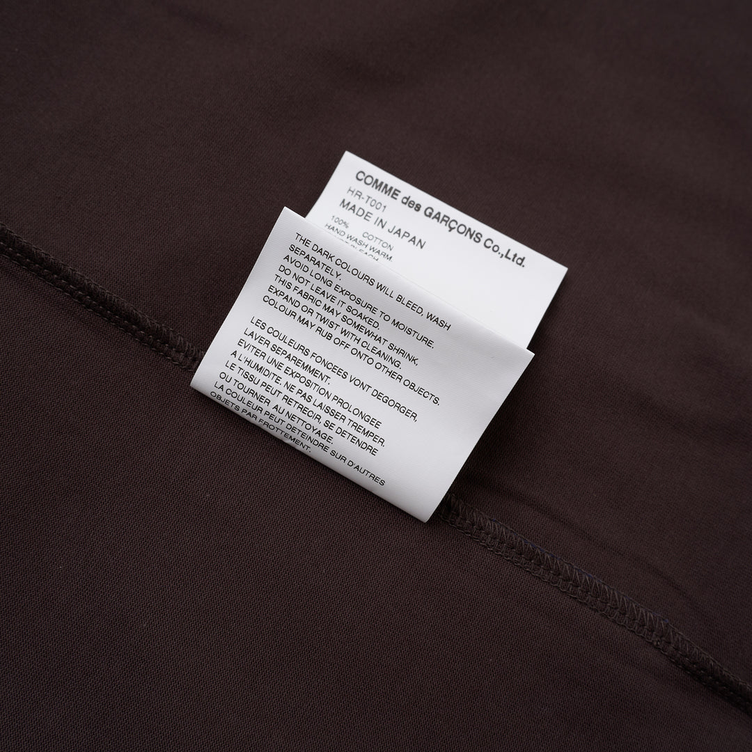 Comme des Garçons Homme Logo Tag Boxy Tee in dark brown with ribbed crewneck, dropped shoulders and wide short sleeves, shown flat from the front - view 4