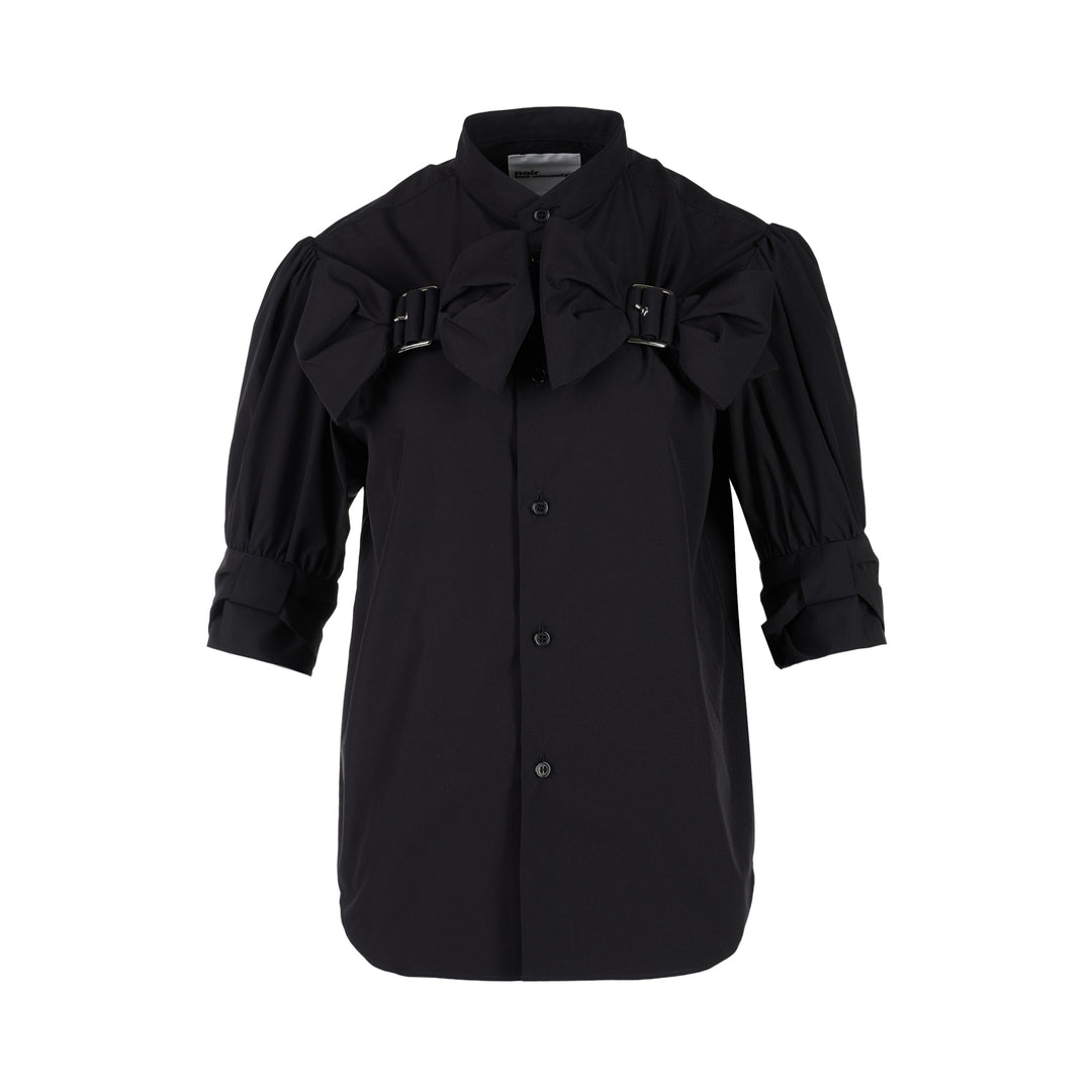 Noir Kei Ninomiya black button-up shirt with band collar, oversized bow with buckle straps across the chest and puffed elbow-length sleeves