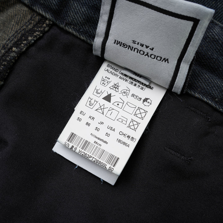 Wooyoungmi wide leg jeans in washed dark indigo denim with paneled knees and square metal waistband hardware, shown flat from the front - view 3