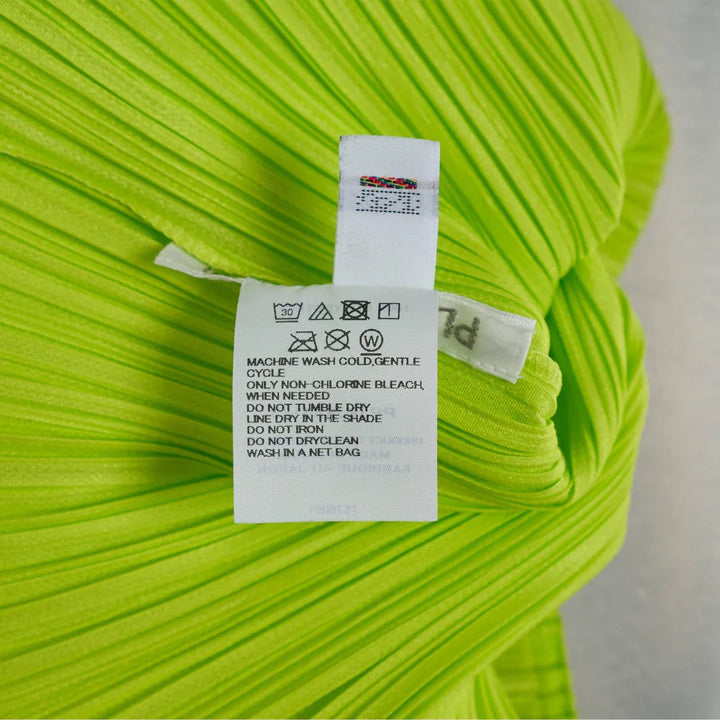 Pleats Please Issey Miyake Colorful Basics Pleated Coat in lime green, back view, showing A-line silhouette and signature pleating texture