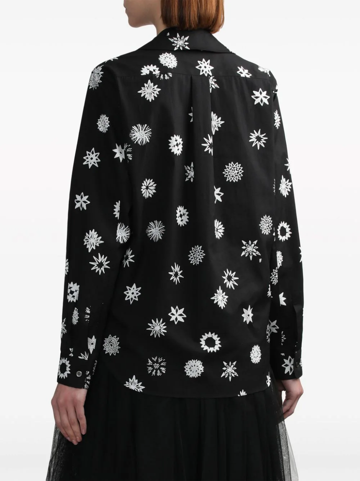 Comme des Garçons BLACK Filip Pagowski print long-sleeve blouse in black with white snowflake motifs, ruffle bib detail, and peter pan collar