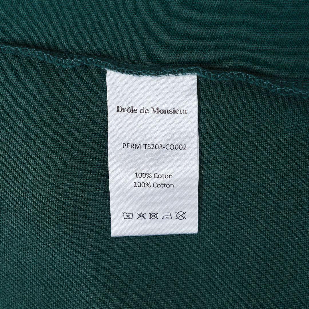 Drôle de Monsieur Not From Paris Madame slogan tee in forest green with white chest print, oversized fit, crew neck