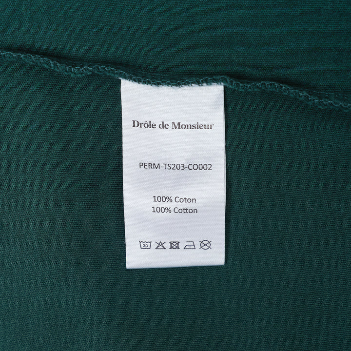 Drôle de Monsieur Not From Paris Madame slogan tee in forest green with white chest print, oversized fit, crew neck