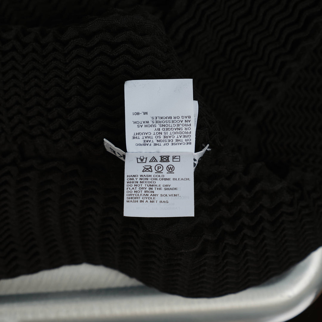 Issey Miyake Spongy Zip-Up Cardigan in black with three-dimensional waffle knit texture, full-length centre zip, and high funnel neck
