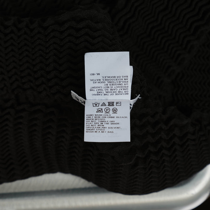 Issey Miyake Spongy Cropped Knit Sweater in black with long sleeves, crew neckline, and textured three-dimensional ribbed construction, displayed on a white background