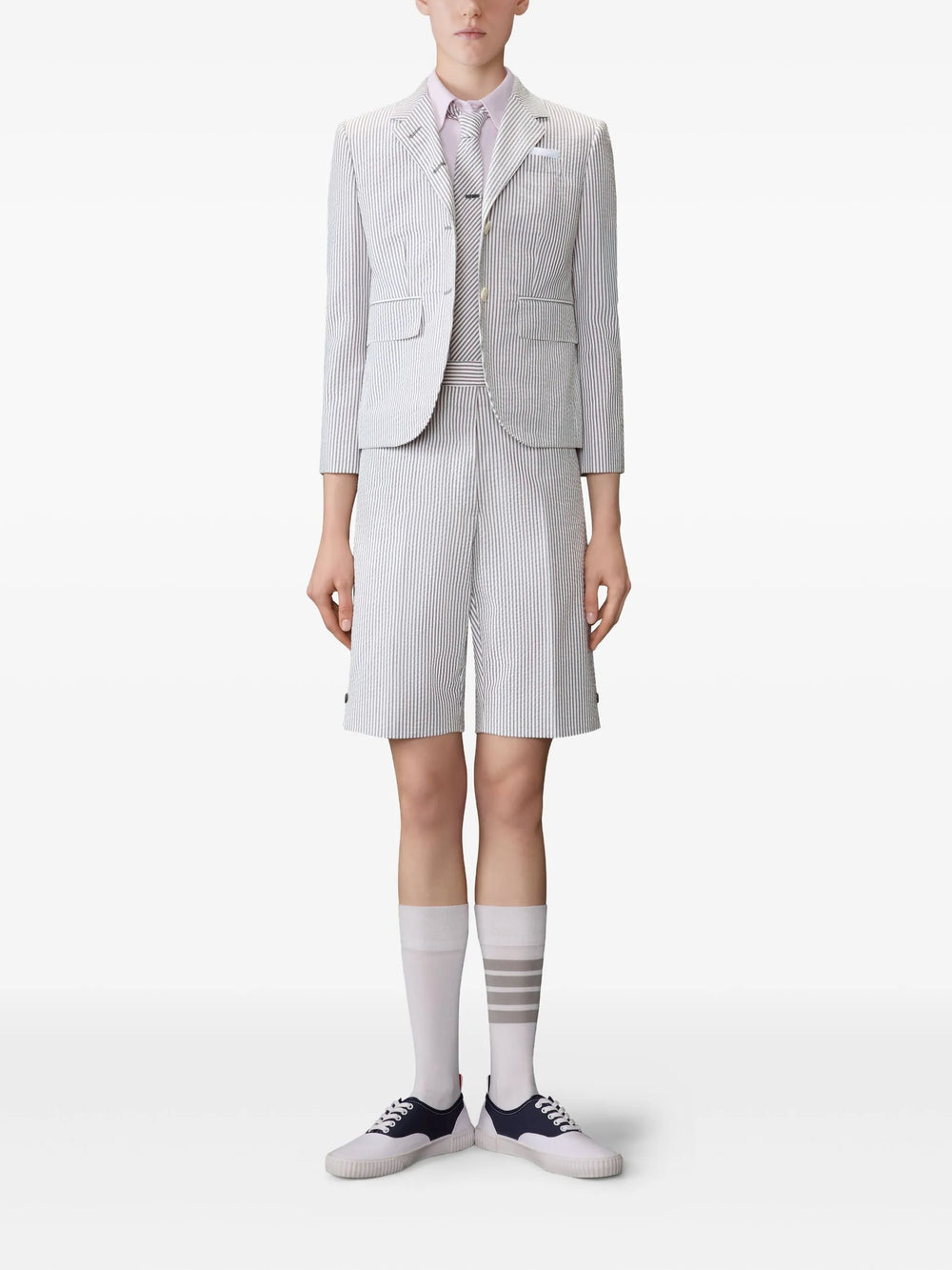 Thom Browne light blue oxford short sleeve shirt with rounded collar and signature woven label at hem, front view