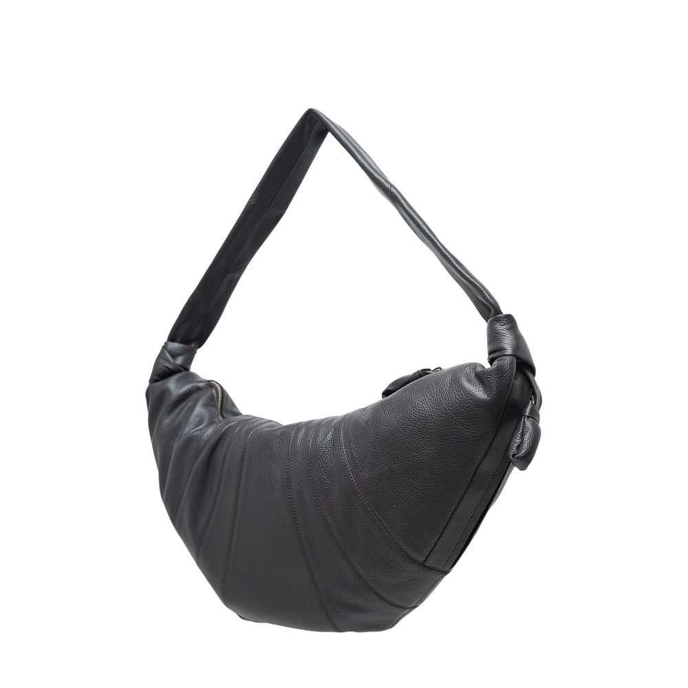Lemaire Large Croissant Bag in black soft-grain leather, featuring a crescent silhouette with radiating pleats, knotted shoulder strap, and top zip closure, photographed against a white background