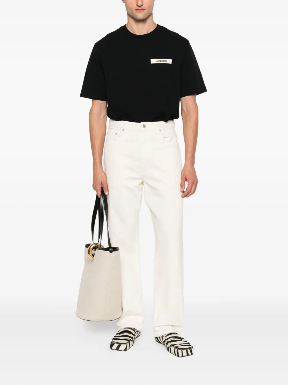 Jacquemus Le T-Shirt Gros Grain in cream with a grosgrain woven logo patch at the chest, laid flat on a white background