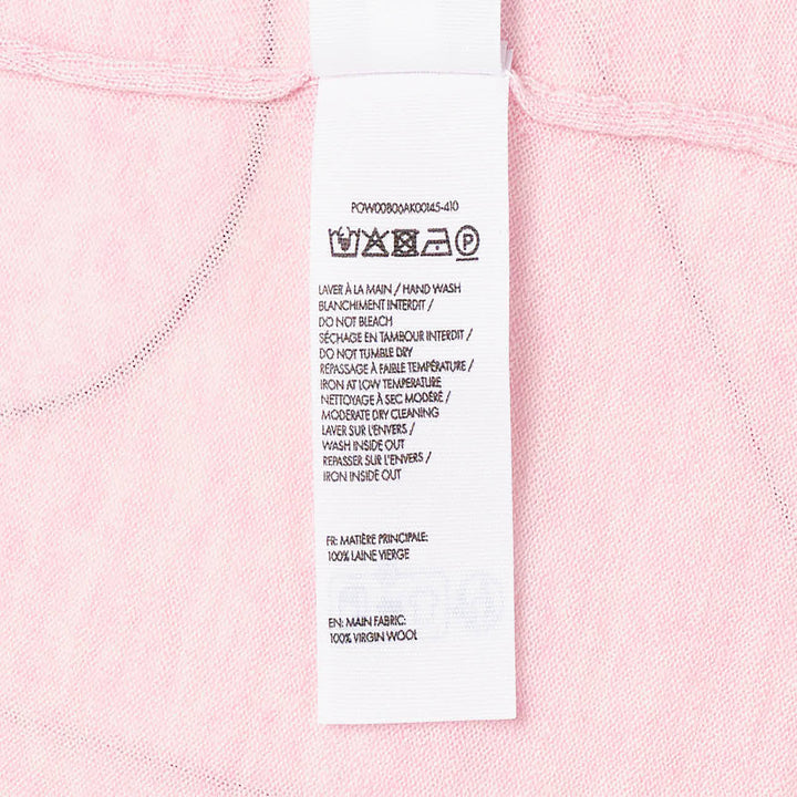 Jacquemus Le Polo Merino long-sleeve knit polo in blush pink with dark snap-button placket, ruched sleeves, and snap-button cuffs, displayed on a flat lay against a white background - view 3
