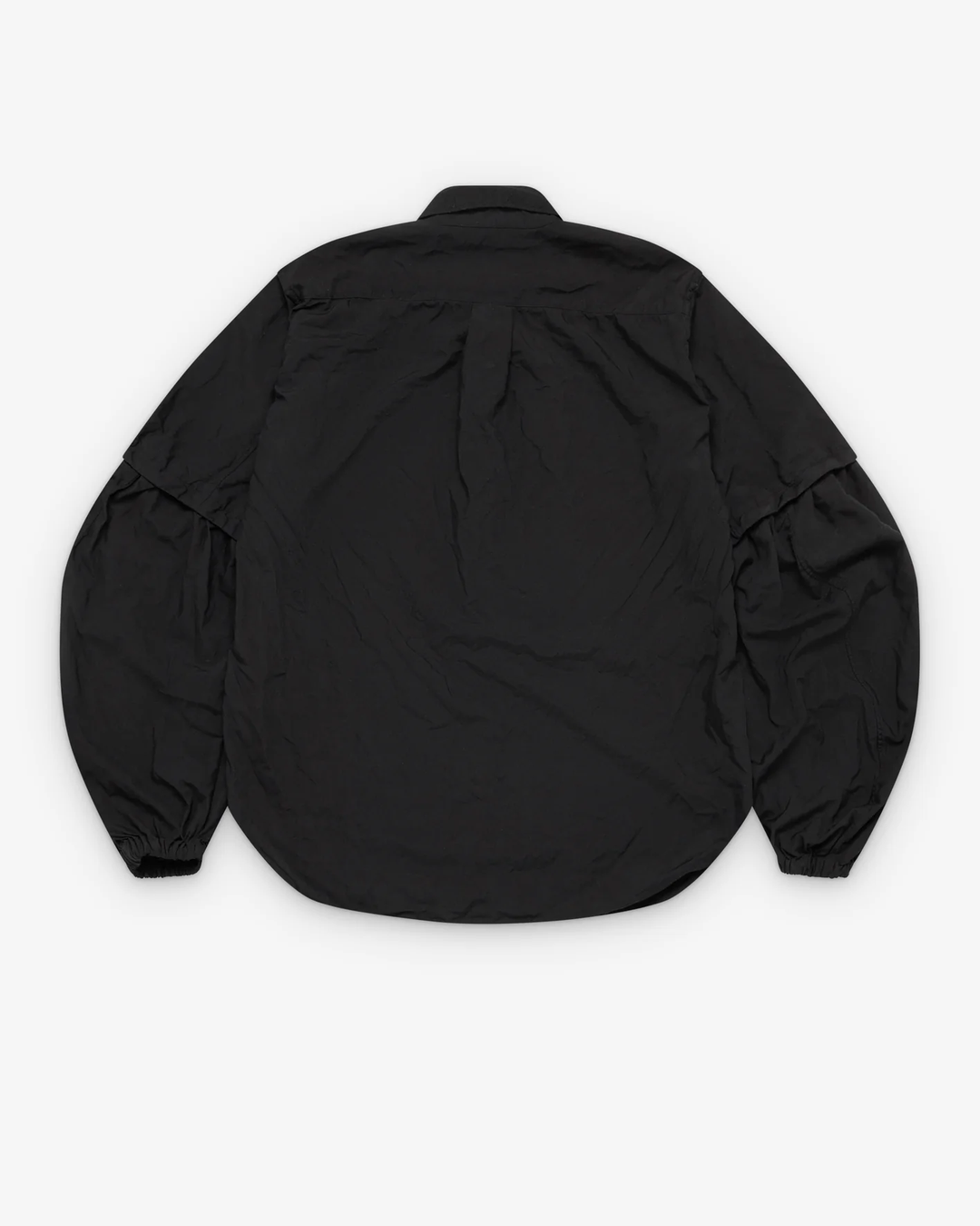 Comme des Garçons BLACK Balloon Long-Sleeved Shirt in black with dramatic puff sleeves, ivory buttons, and elasticated cuffs, laid flat on white background