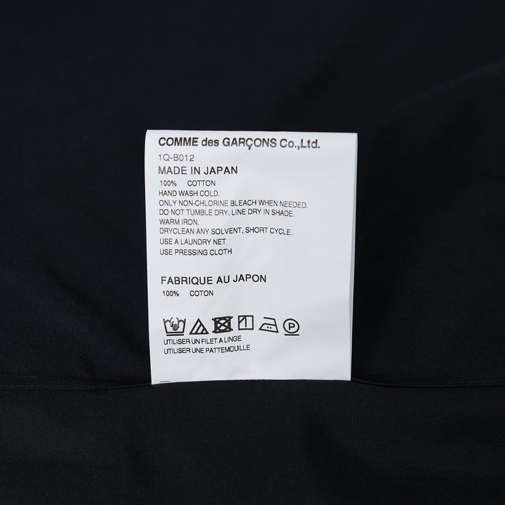 Comme des Garçons BLACK white long sleeve shirt with rounded Peter Pan collar and chest pocket, front view on white background