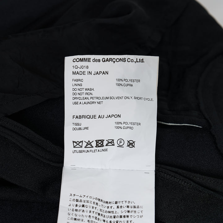 Comme des Garçons BLACK Freedom Jacket in black with Peter Pan collar, tonal button front, flap pockets, and scalloped raw-edge hem