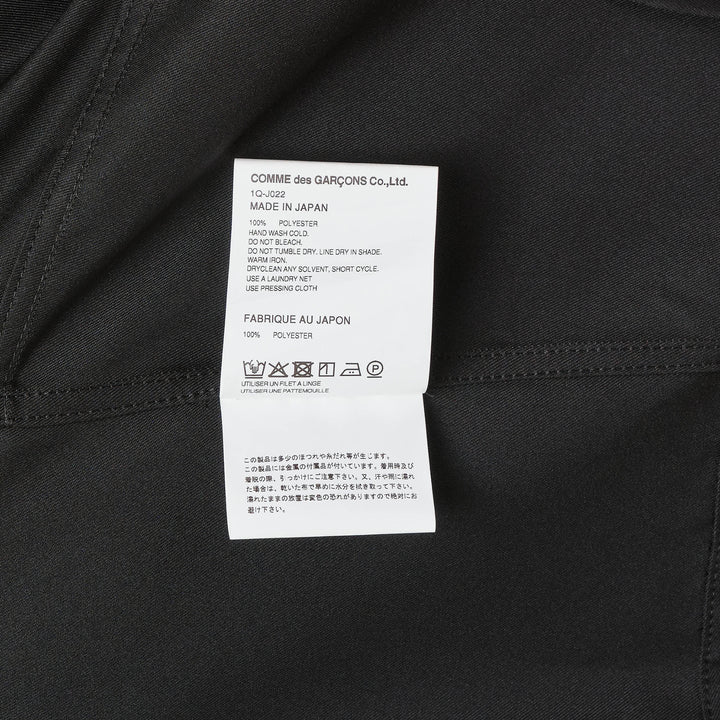Comme des Garçons BLACK sleeveless off-center jacket in black with asymmetric hem, button front, and dual chest flap pockets