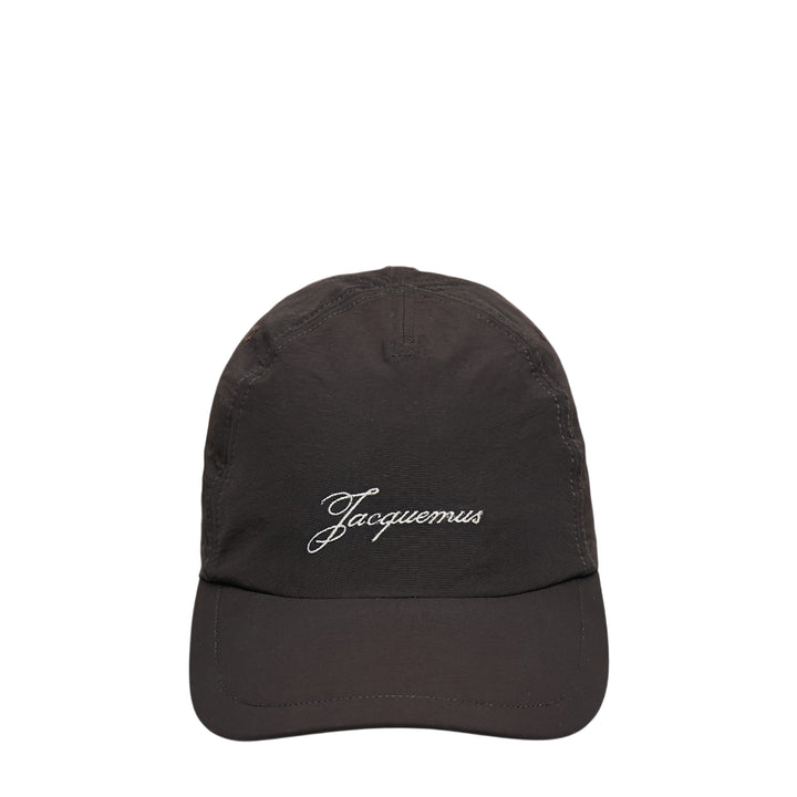Jacquemus La Casquette Baluchon dark baseball cap with white script logo embroidery on the front panel, front view