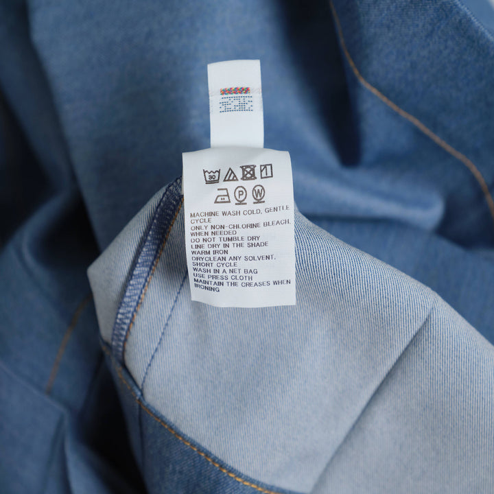 me Issey Miyake Flat Denim Jacket in light blue with purple buttons and contrast gold topstitching, flat lay front view
